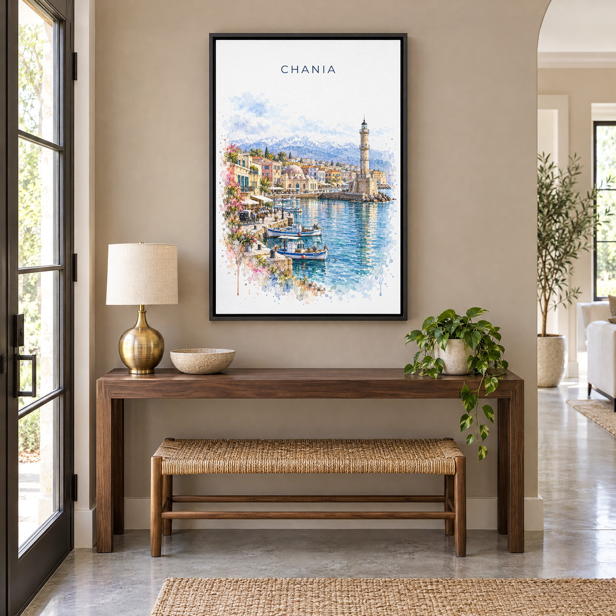 Chania watercolor print as a black floater canvas above a walnut console and woven bench in an entryway