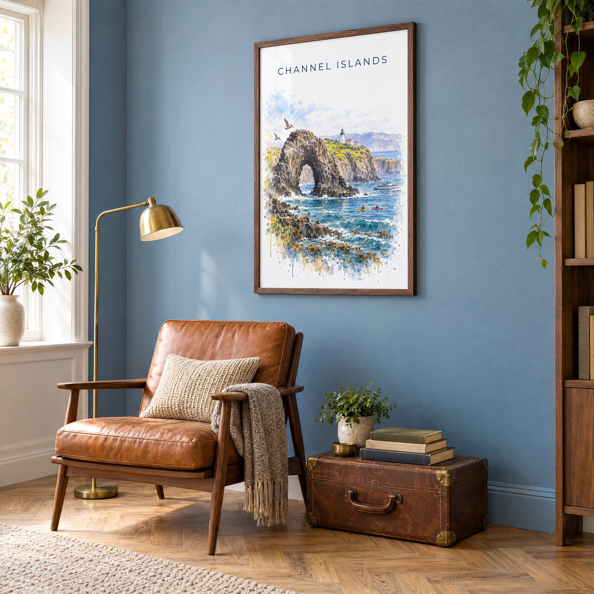 Channel Islands National Park watercolor print in a walnut frame on a blue wall above a leather armchair in a reading nook