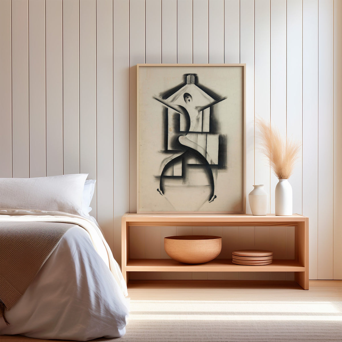 Charcoal dancer in house frame sketch print in a light oak frame on a wood bench by a bed with pampas grass