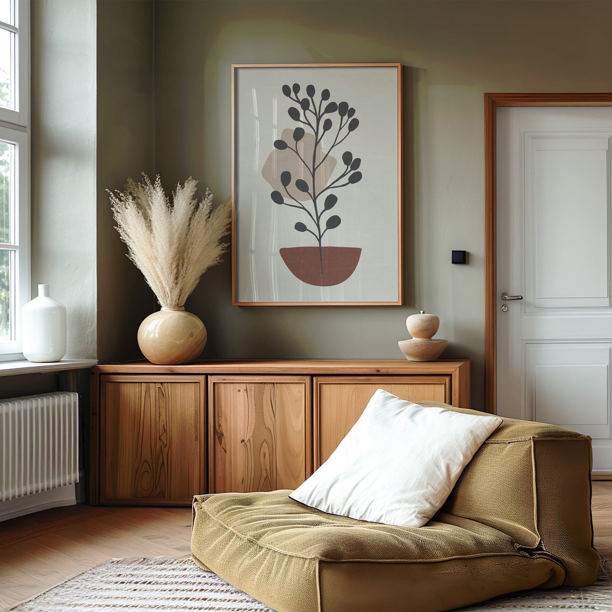 Charcoal plant in a rust bowl abstract botanical print in an oak frame on an olive green wall above a wood sideboard with pampas