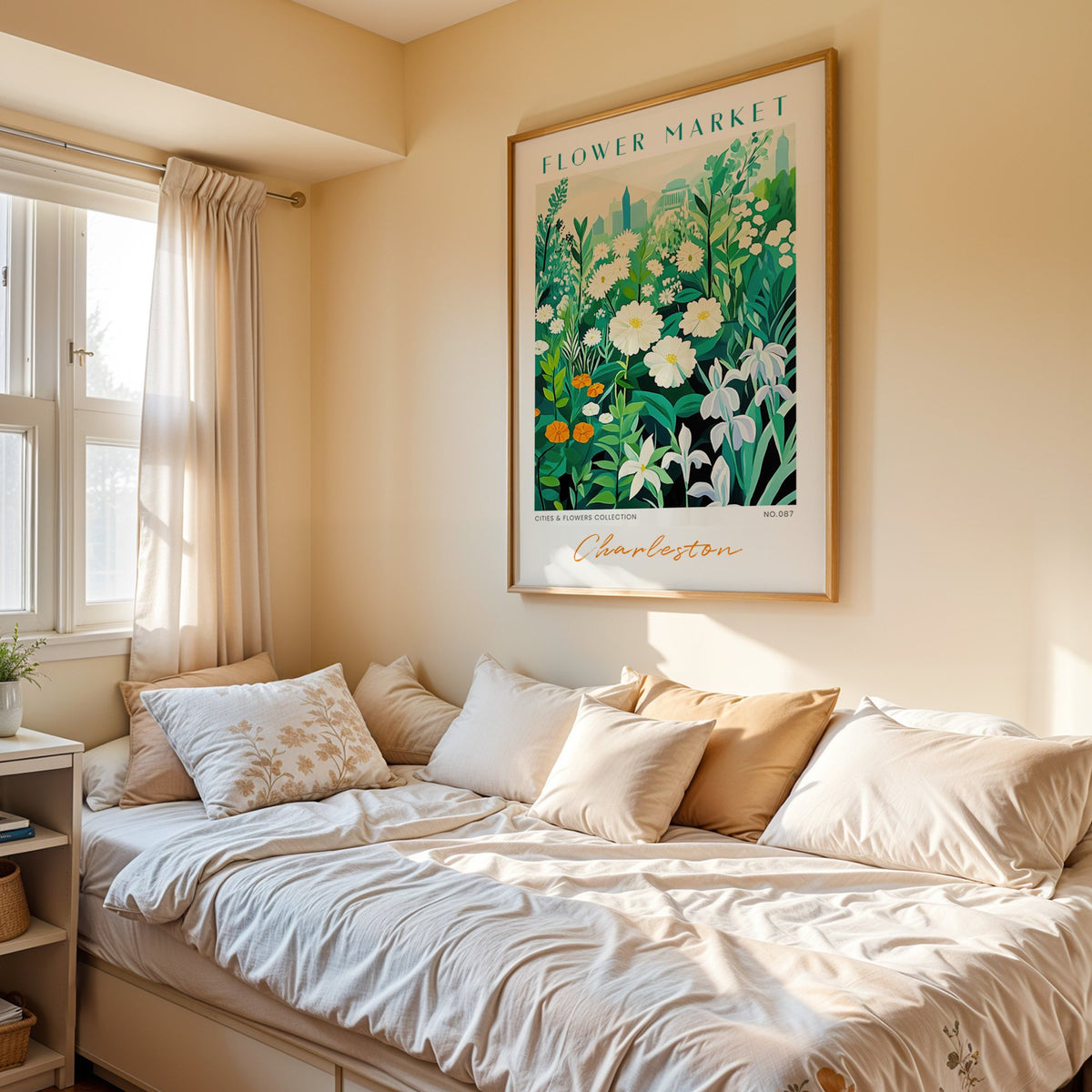 Charleston flower market print in an oak frame above a cream daybed in a sunny bedroom