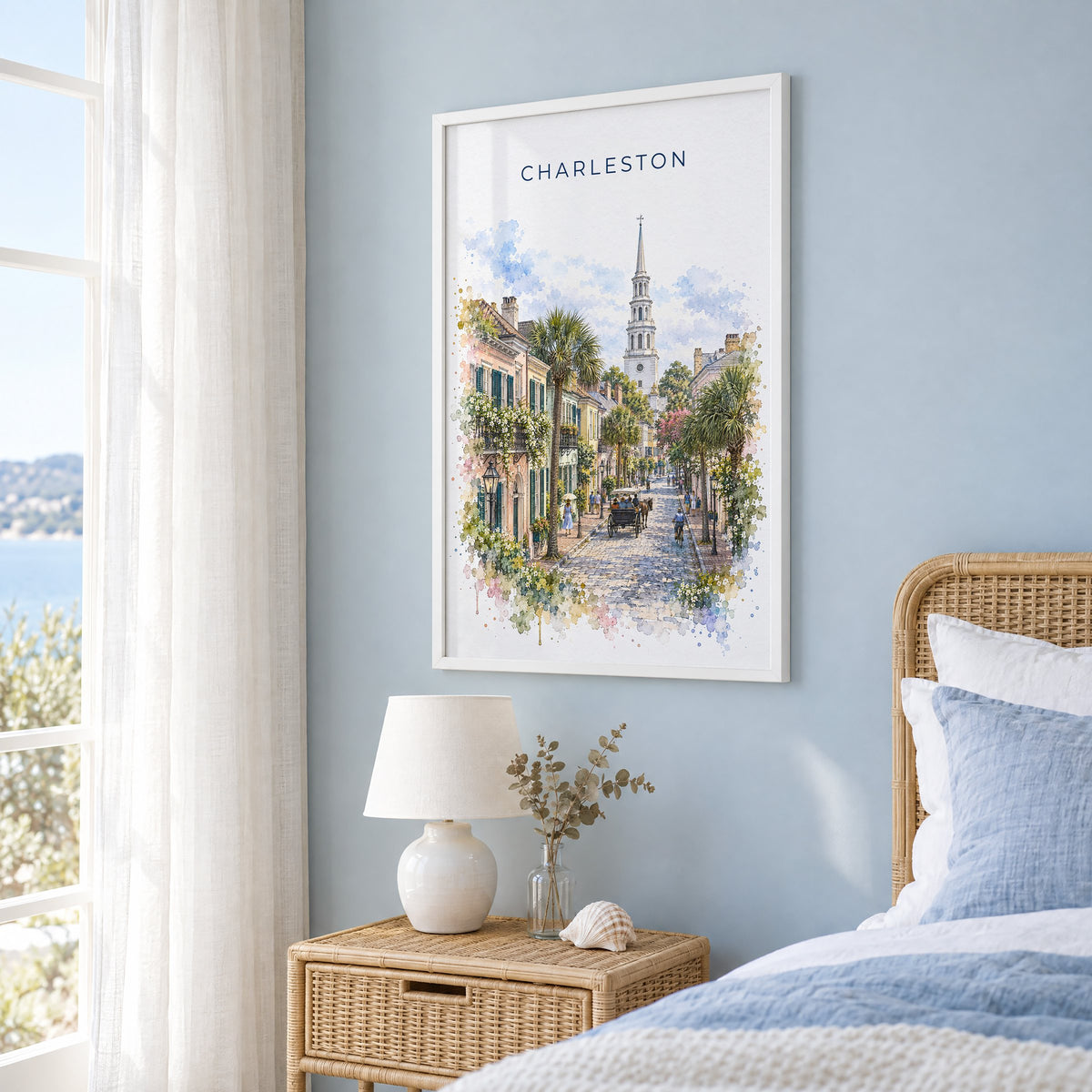 Charleston watercolor print in a white frame on a pale blue wall beside a rattan bed in a coastal bedroom