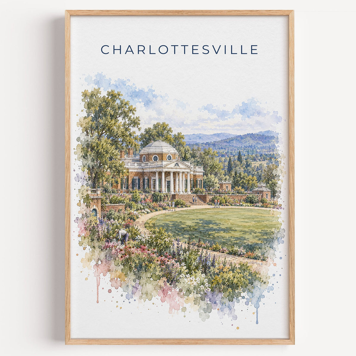 Charlottesville watercolor print in a light oak frame on a plain white wall