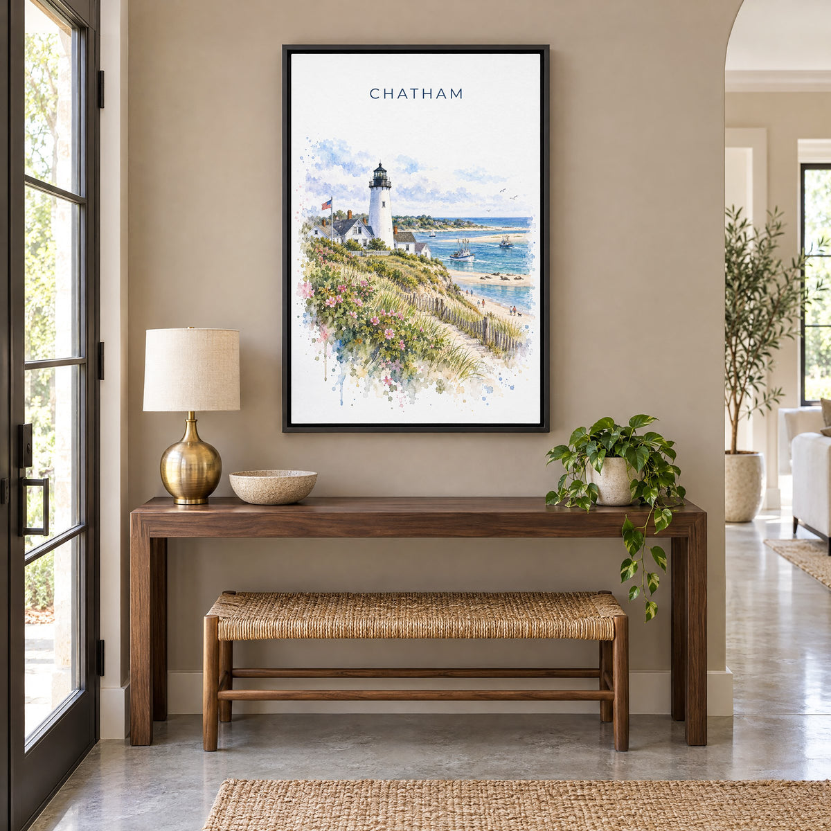 Chatham, Massachusetts watercolor print as a black floater canvas above a walnut console and woven bench in an entryway