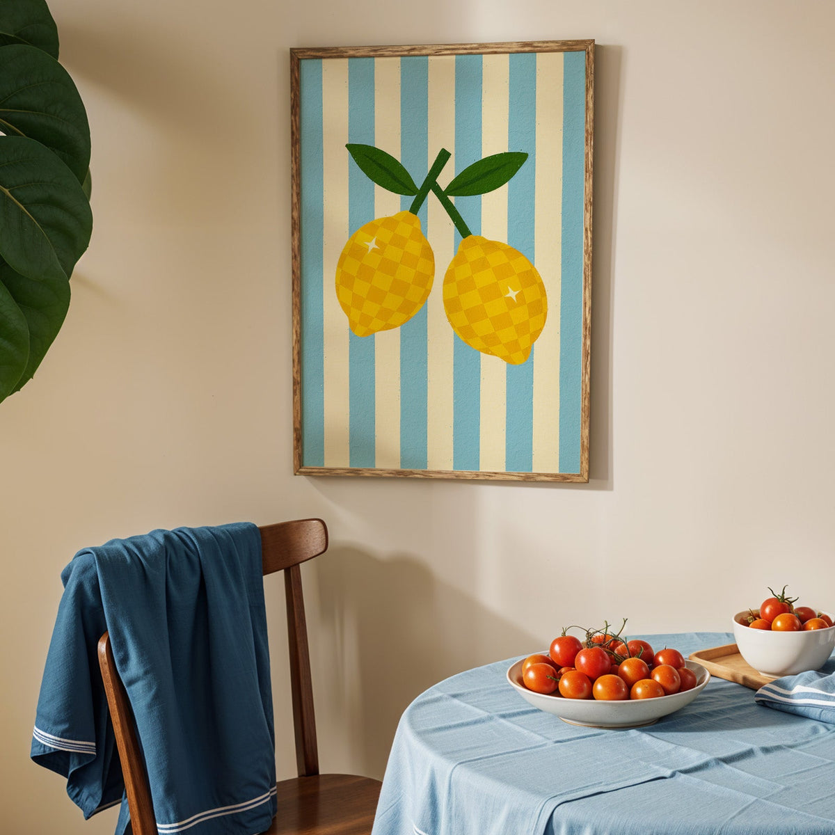 Checkered lemons print in an oak frame above a blue linen table with tomatoes
