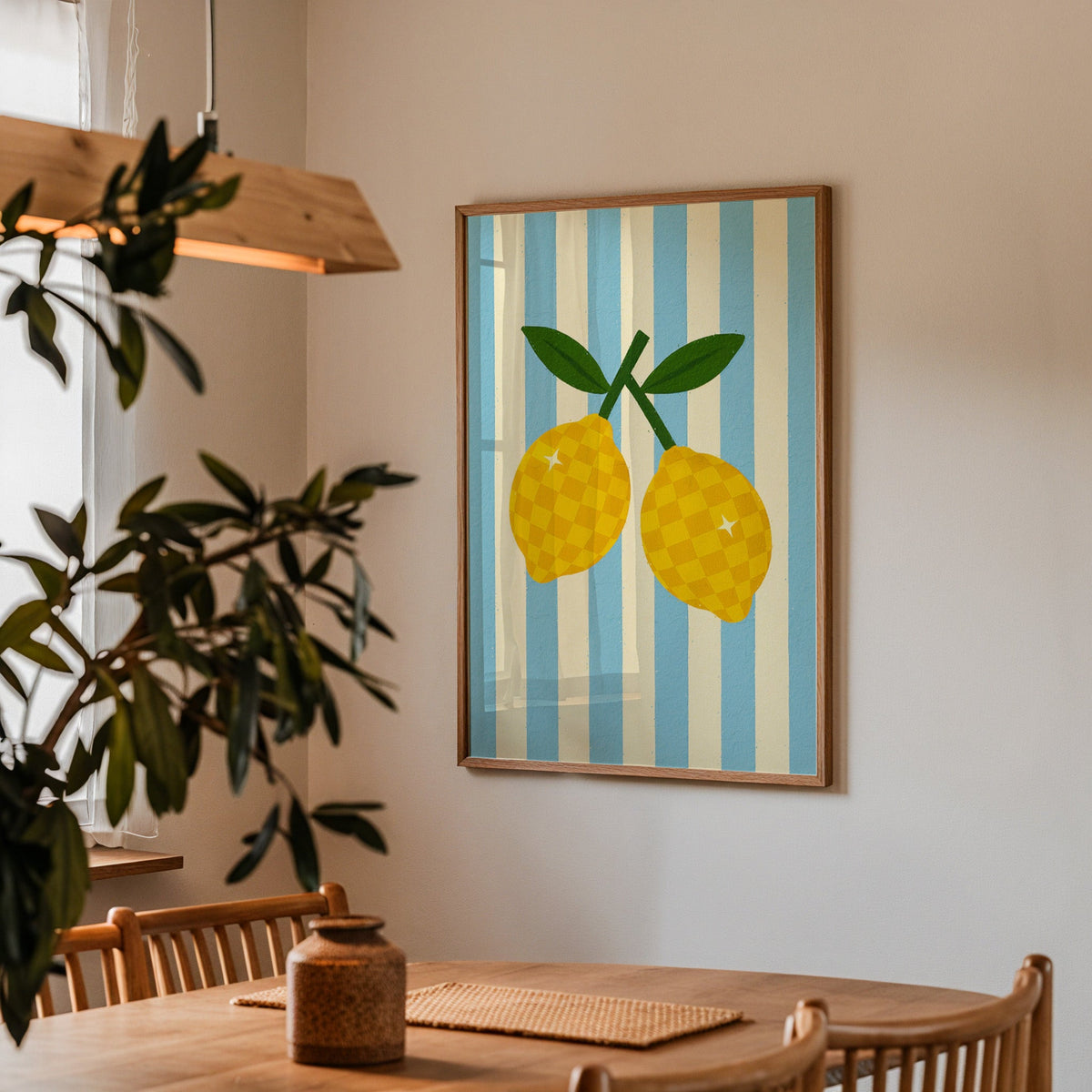 Checkered lemons print in a walnut frame above a dining table by an olive tree