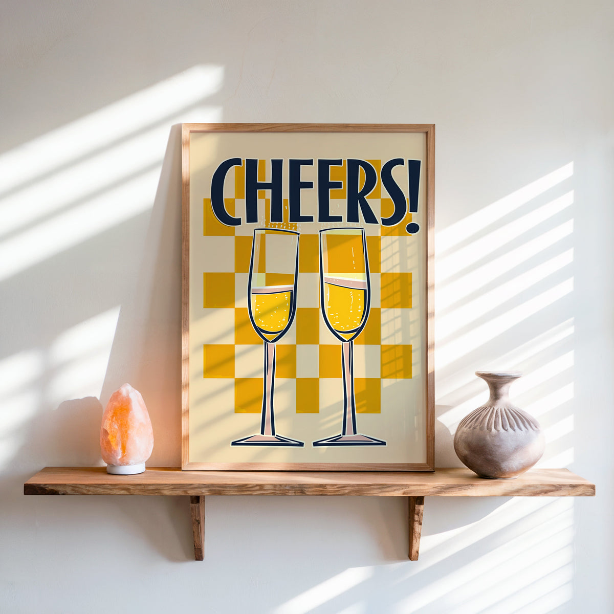 Cheers champagne flutes print in an oak frame on a live-edge shelf beside a salt lamp