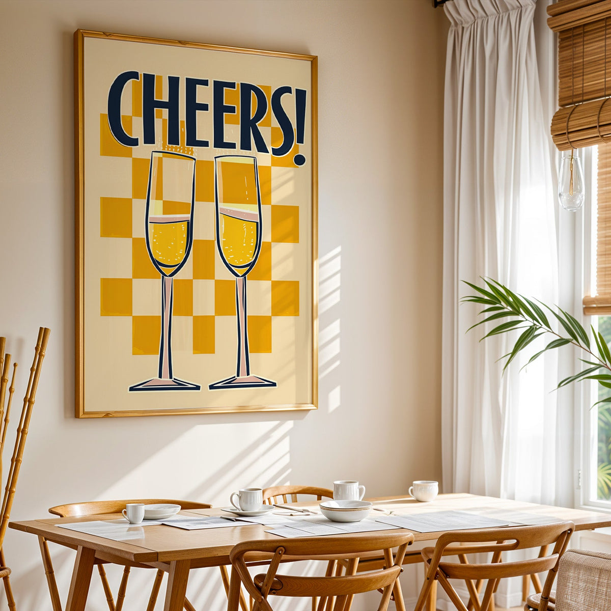 Cheers champagne flutes print shown in a gold frame above a breakfast table by a curtained window