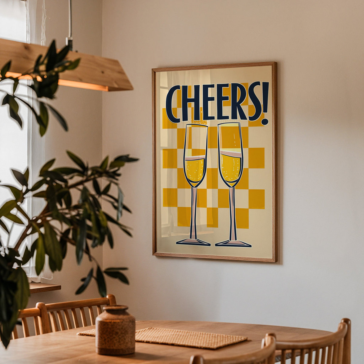 Cheers champagne flutes print in a walnut frame above a dining table with olive branches