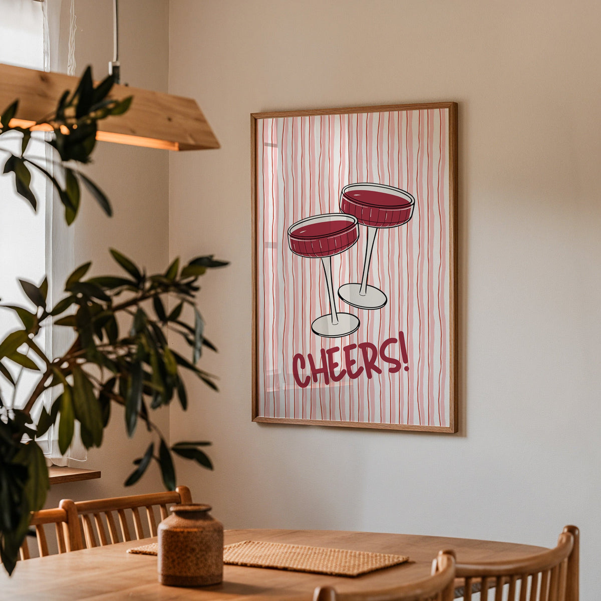 Cheers coupes print in a walnut frame above a dining table with olive branches