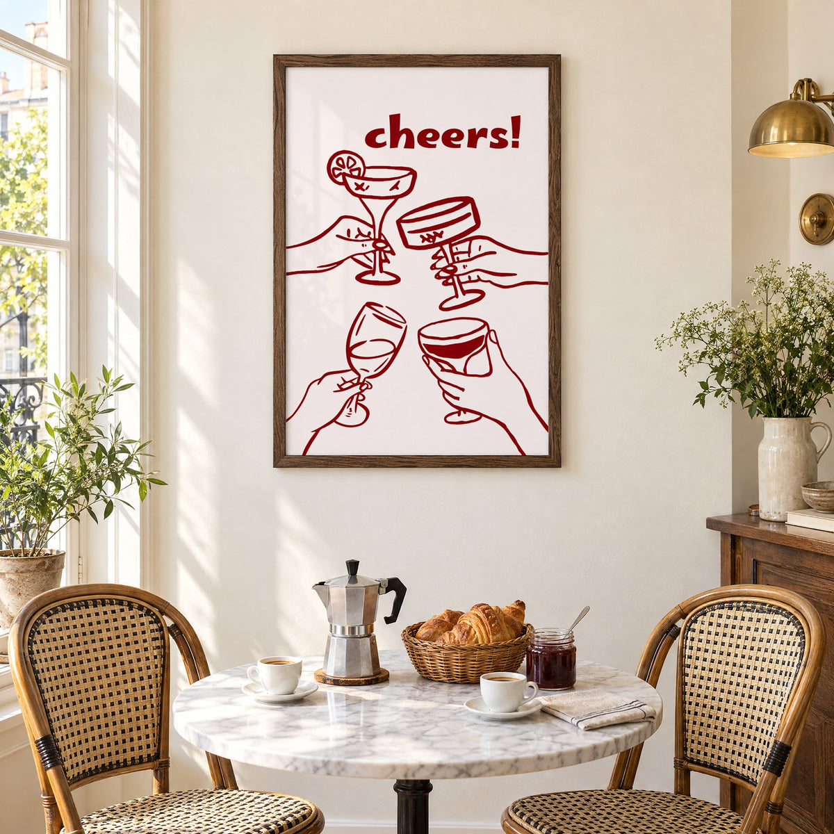 cheers! four hands toasting burgundy line print in a walnut frame above a marble bistro table with croissants and rattan chairs