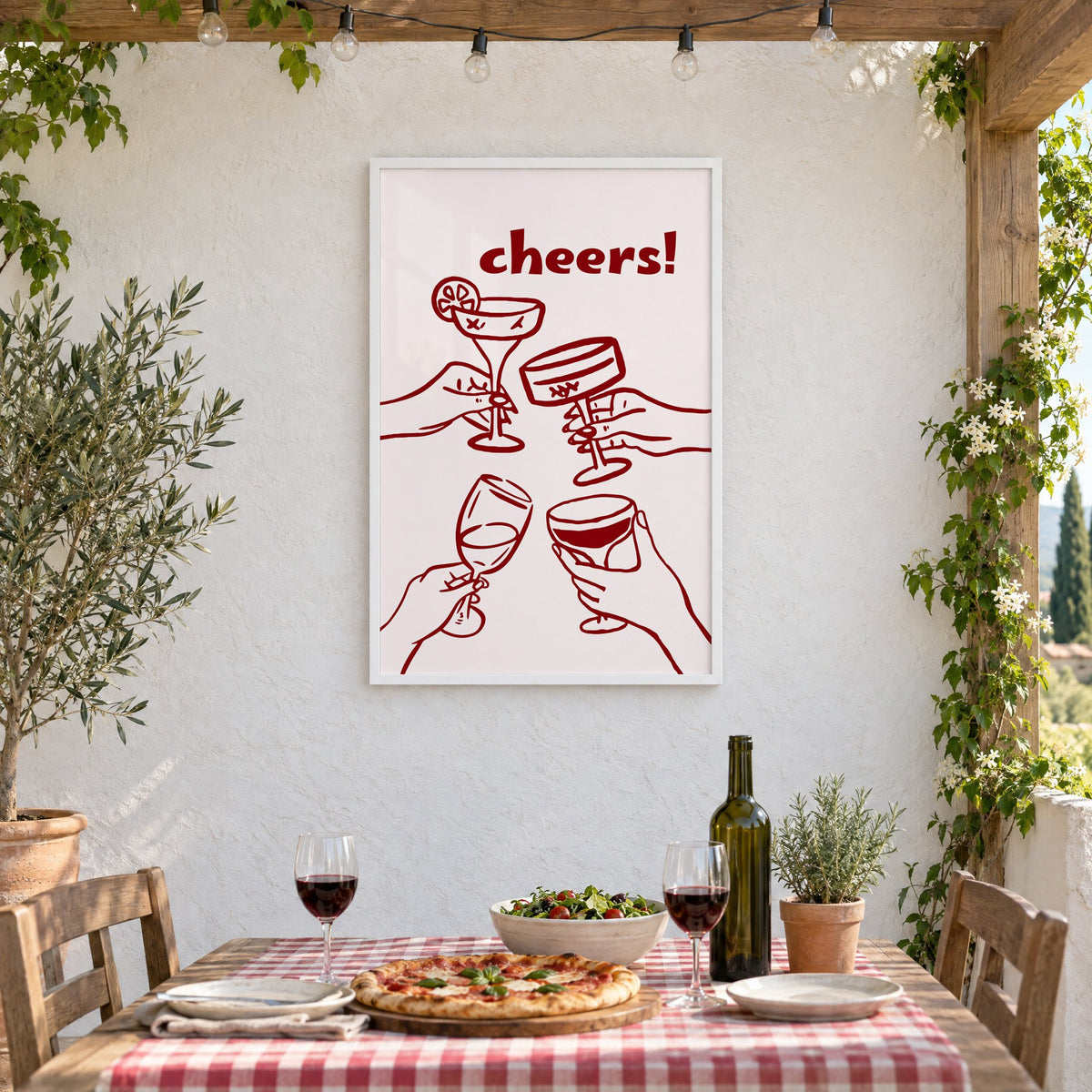 cheers! four hands toasting burgundy line print in a white frame on a stucco wall above a checked-cloth table with pizza and red wine