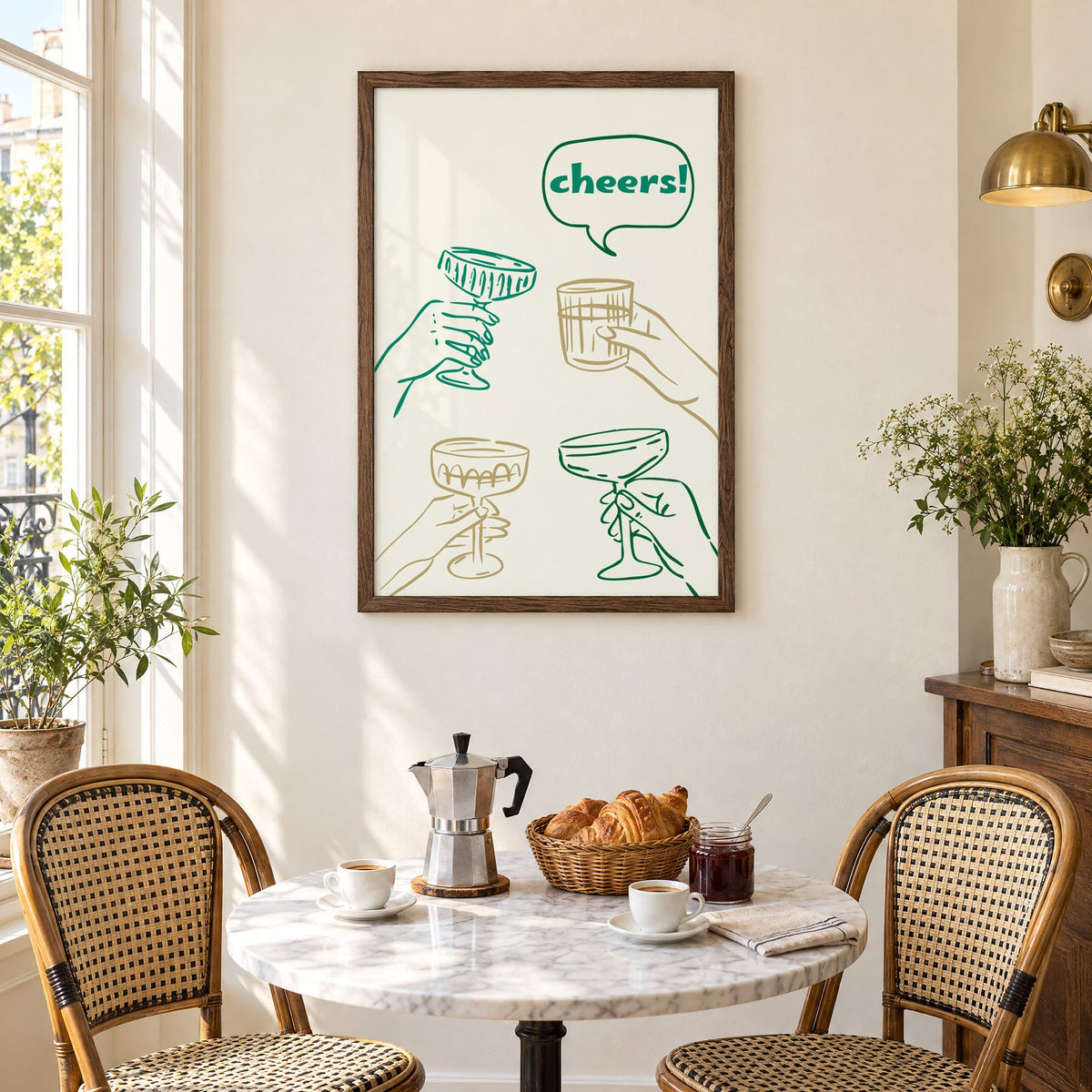 cheers! hands toasting coupes teal and gold print in a walnut frame above a marble bistro table with croissants and rattan chairs