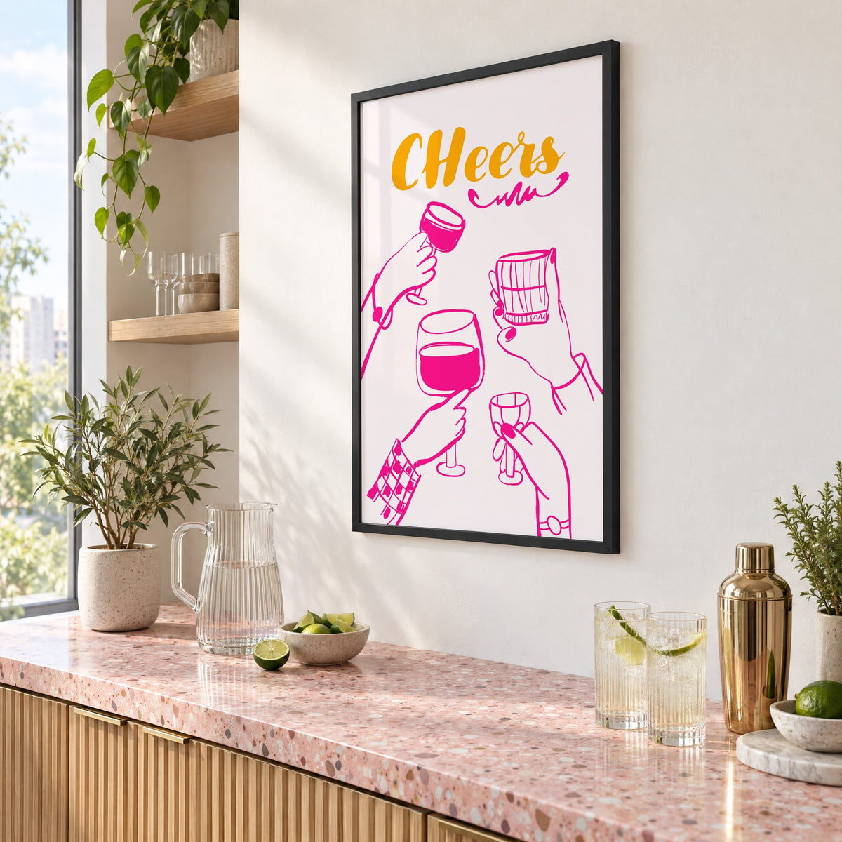 CHeers hot pink toasting hands print in a black frame above a pink terrazzo cocktail counter with limes, seen at an angle