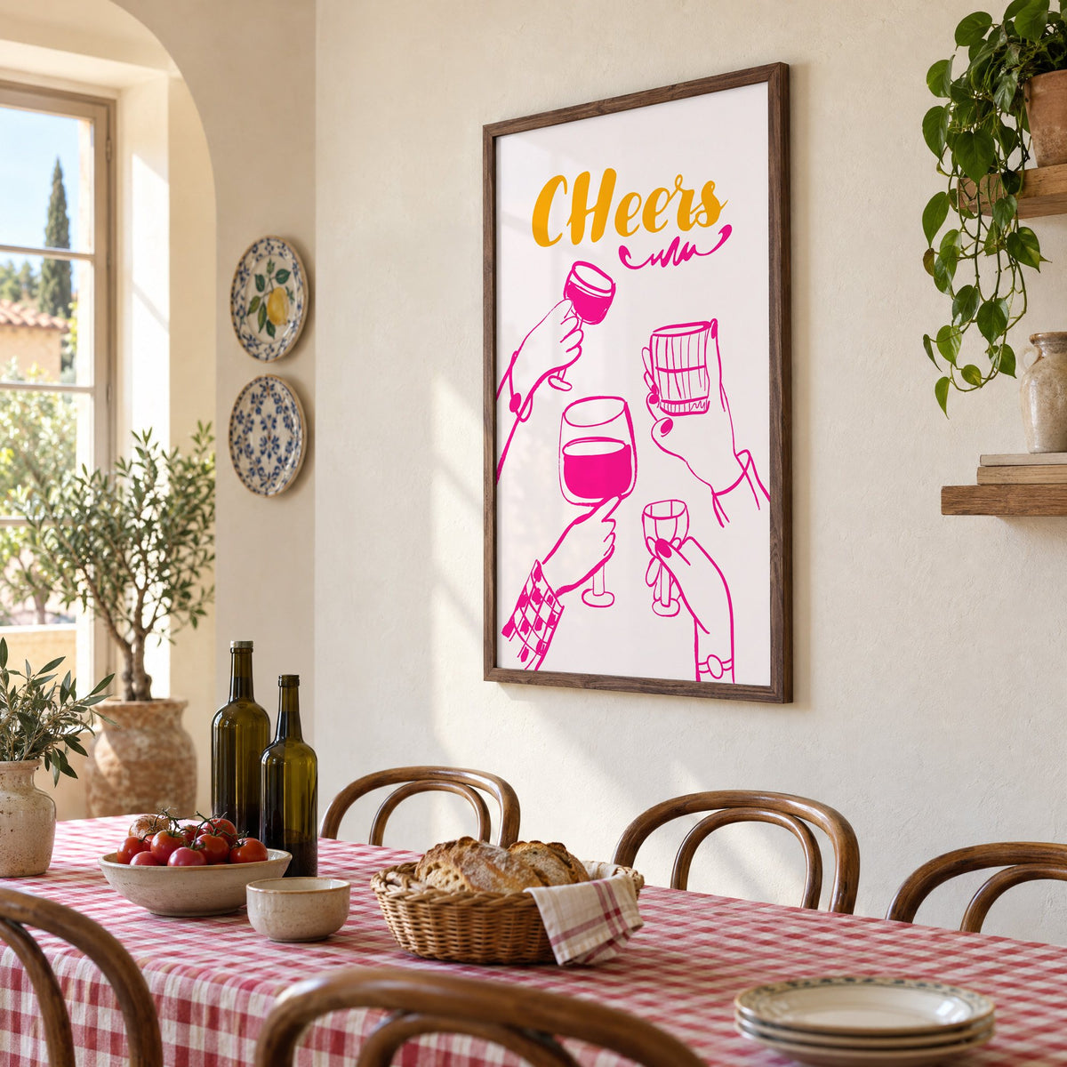 CHeers hot pink toasting hands print in a walnut frame above a gingham-covered trattoria table, seen at an angle