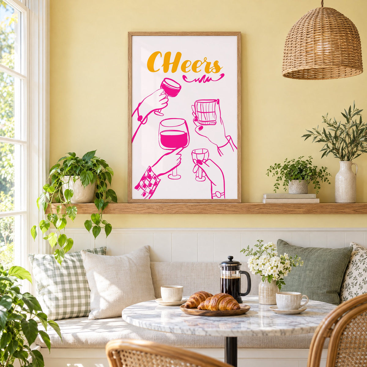CHeers hot pink toasting hands print in an oak frame on a picture ledge above a sunny breakfast nook