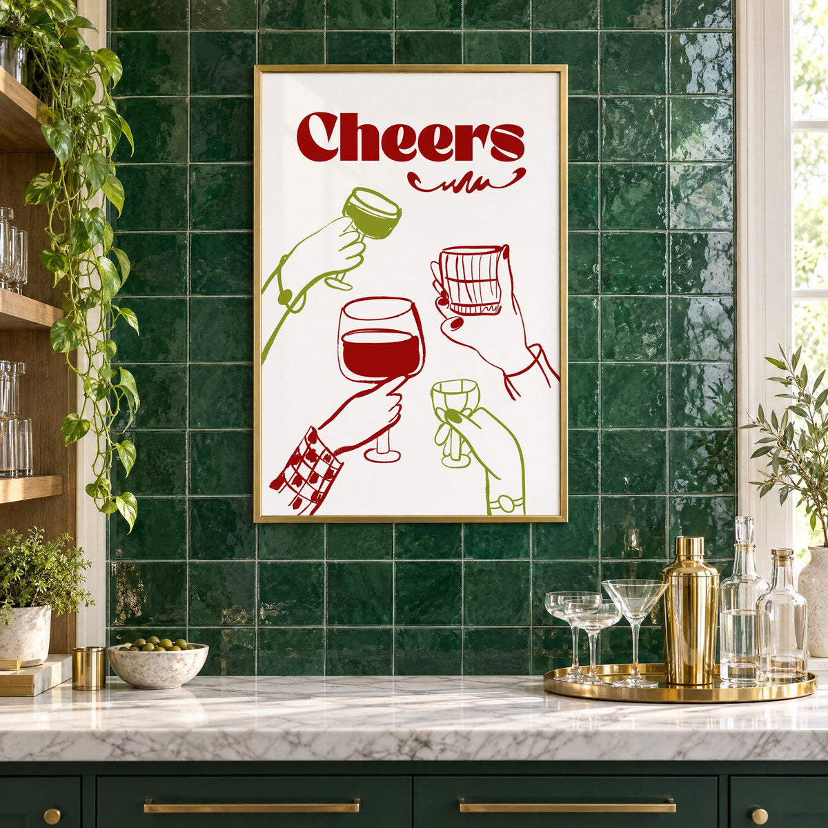 Cheers red and olive toasting hands print in a brass frame on emerald green tiles above a home bar with coupe glasses