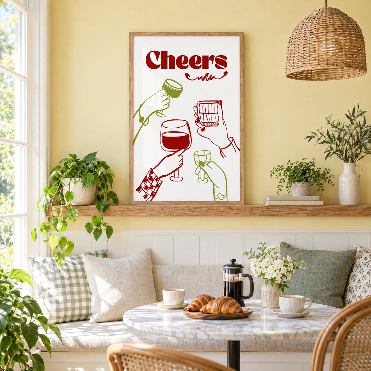 Cheers red and olive toasting hands print in an oak frame on a picture ledge above a sunny breakfast nook