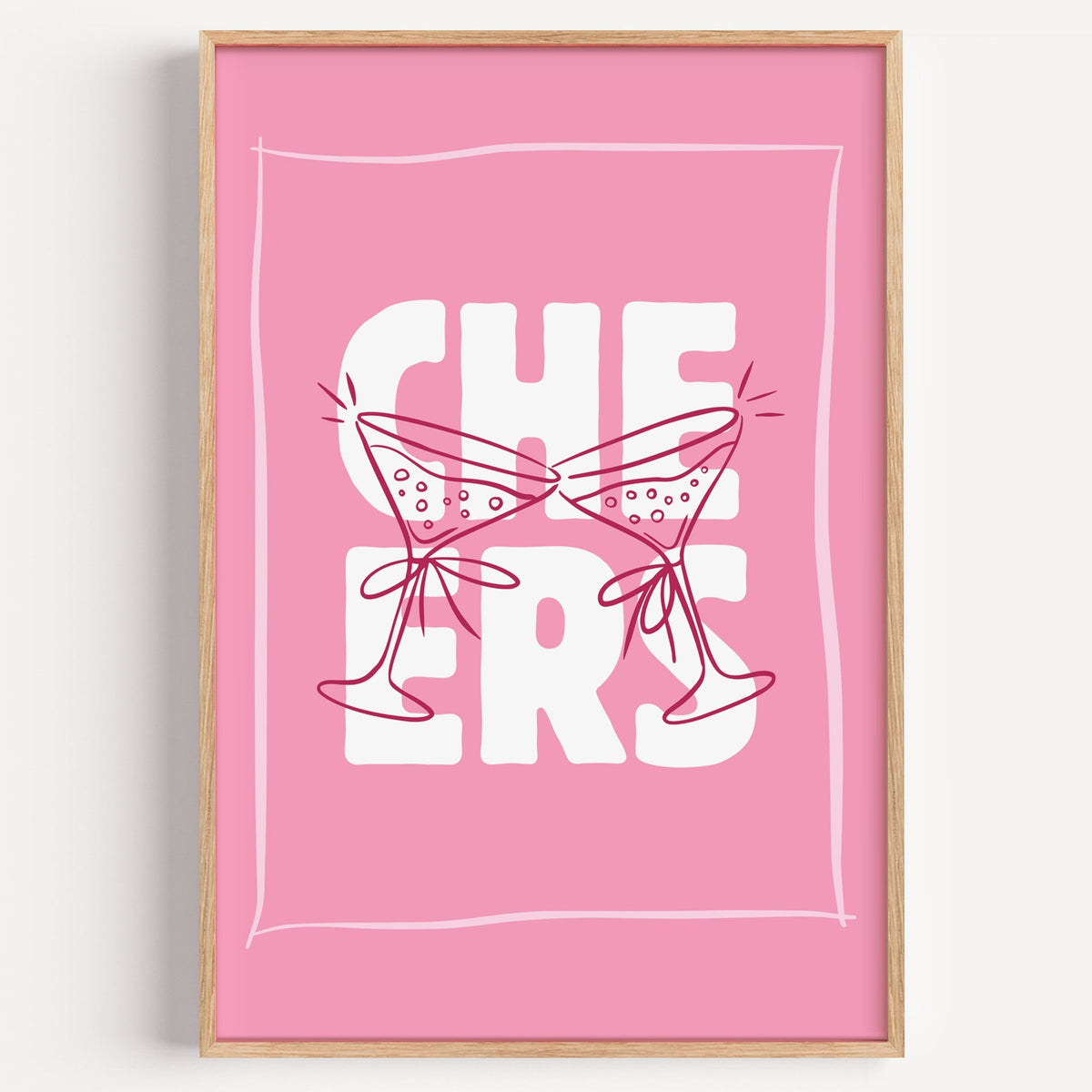 Cheers martini print in a light oak frame on a plain white wall