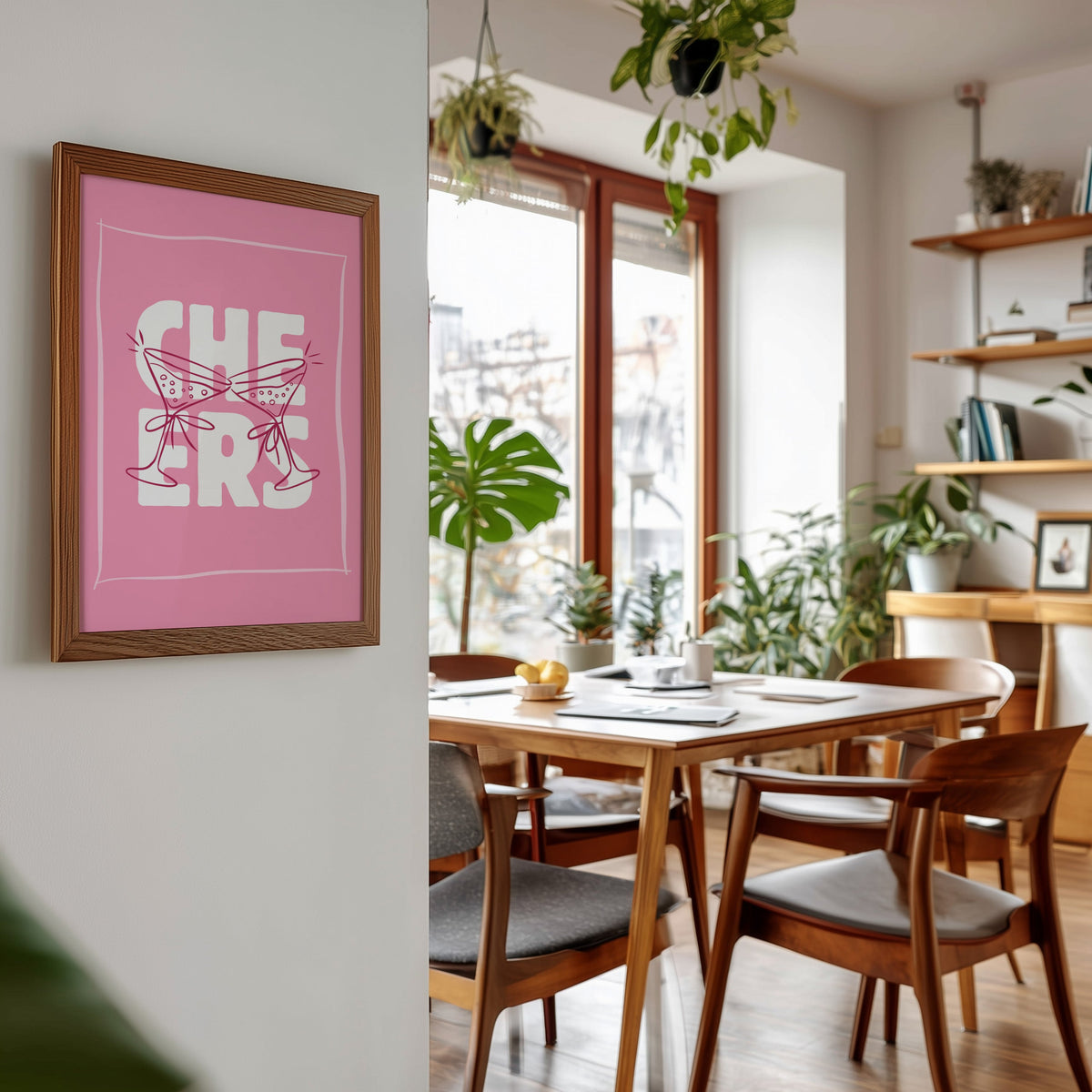 Cheers martini print in a walnut frame beside a mid-century dining table