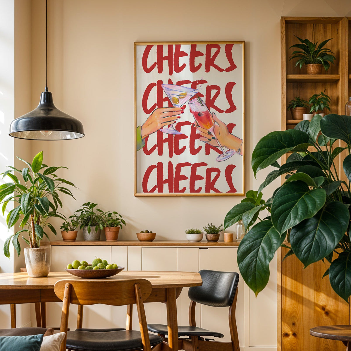 Cheers repeat type print in an oak frame in a dining room above a plant-lined sideboard