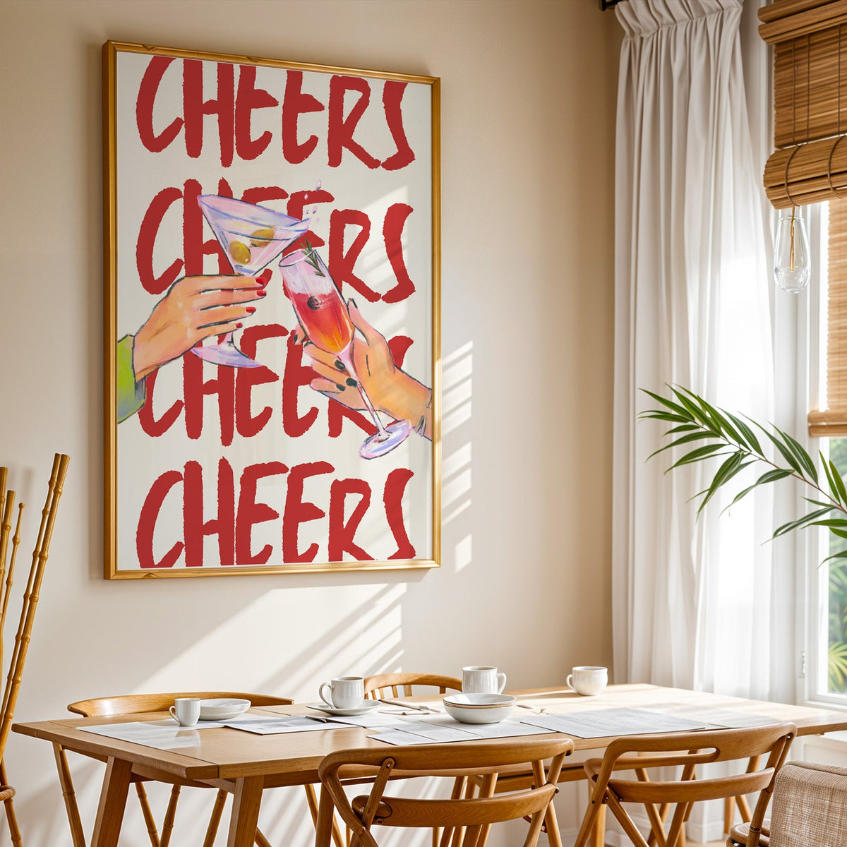Cheers repeat type print shown in a gold frame above a breakfast table by a curtained window
