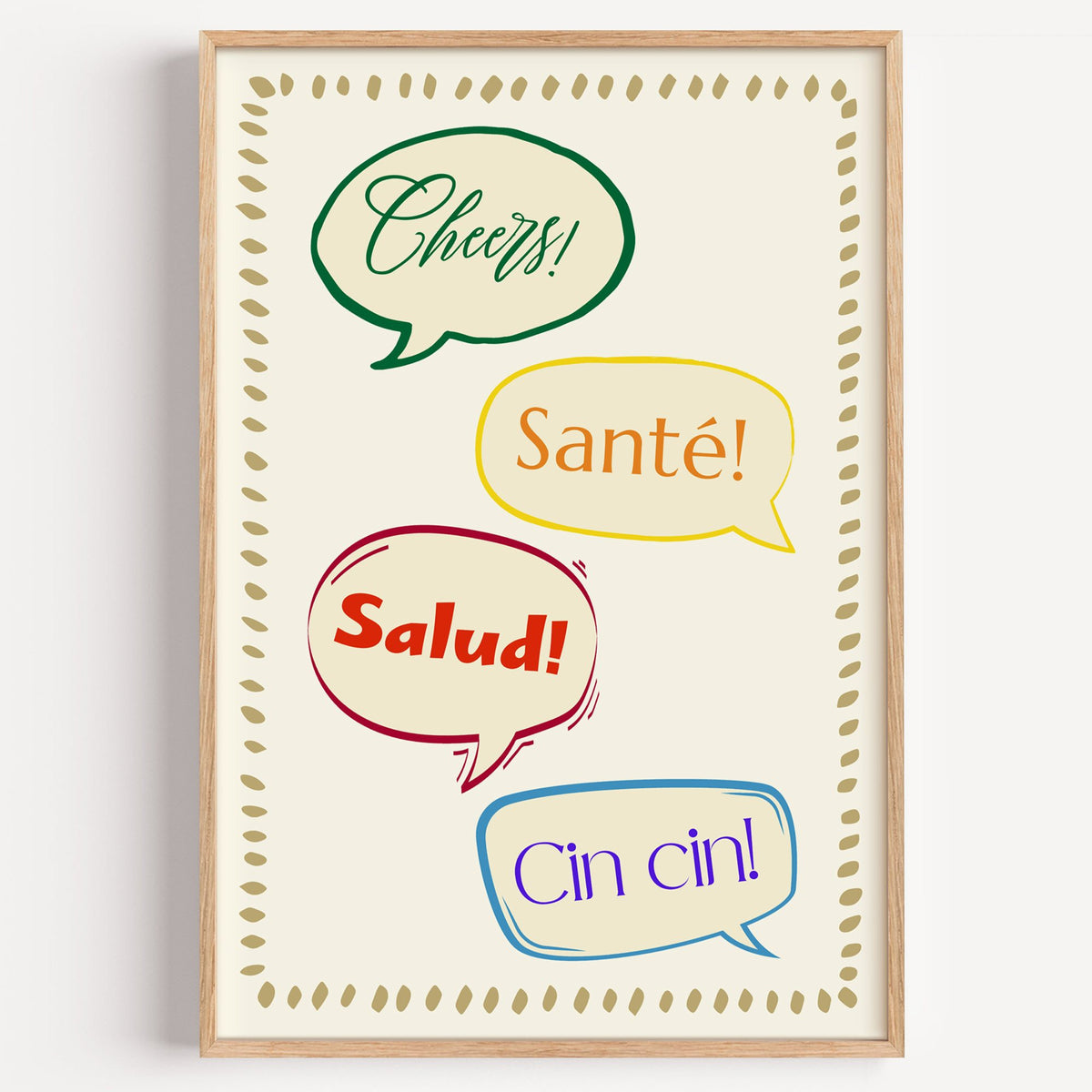 Cheers! Santé! Salud! Cin cin! speech bubbles print in a light oak frame on a plain white wall