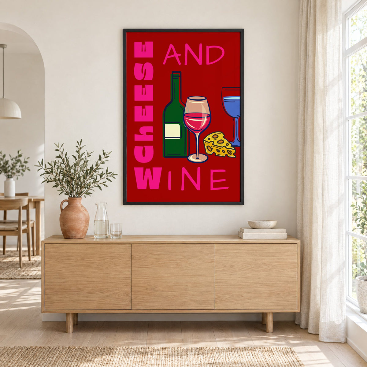Cheese and wine bold red pink print in a black frame above an oak sideboard with a terracotta vase of olive branches