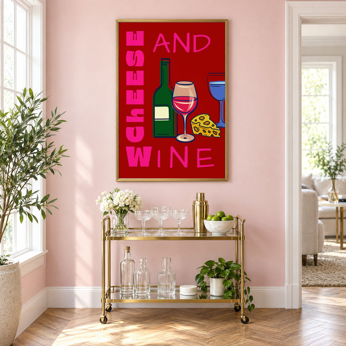 Cheese and wine bold red pink print in a brass frame above a gold bar cart on a blush pink wall