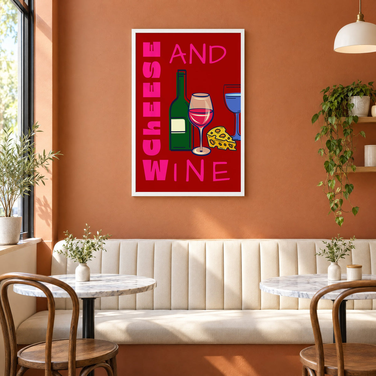 Cheese and wine bold red pink print in a white frame above a cream banquette on a terracotta cafe wall