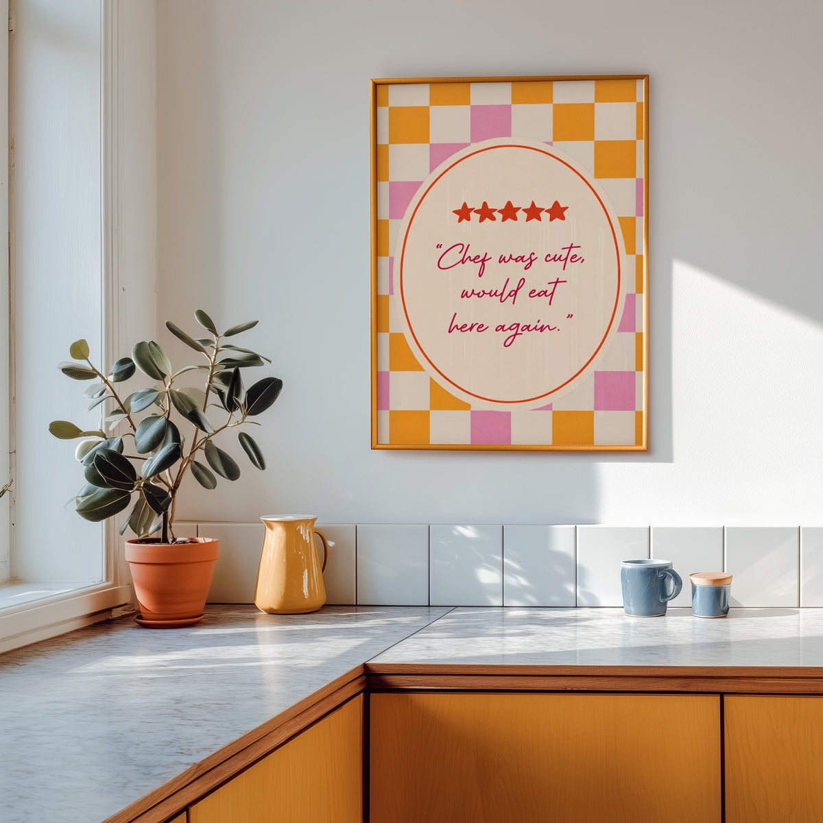 Chef Was Cute print shown in a gold frame above a marble counter with a yellow ceramic jug
