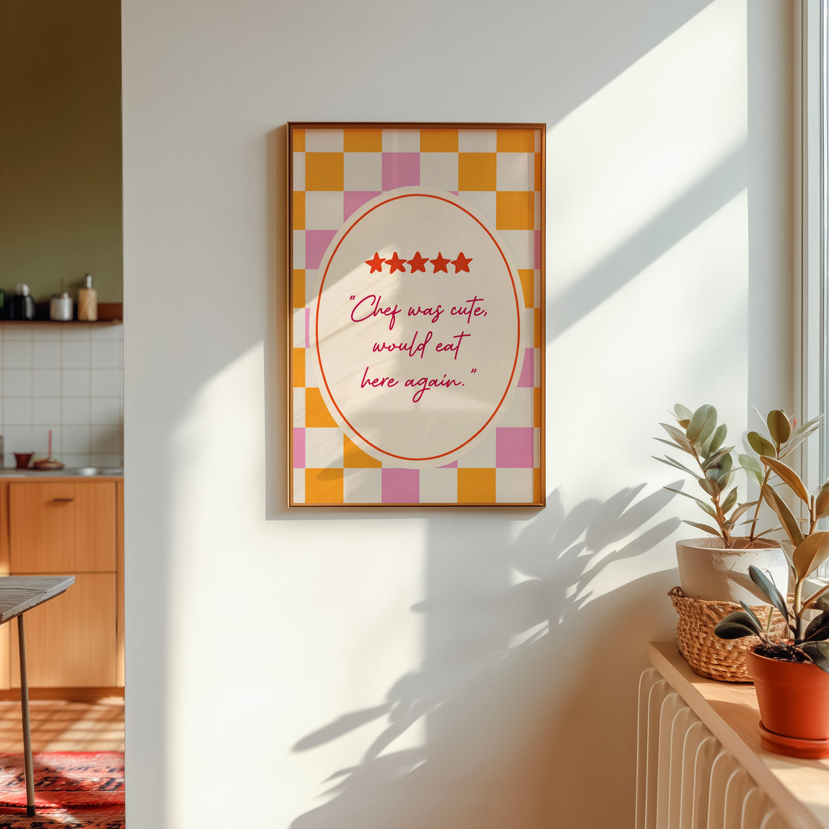 Chef Was Cute print shown in a gold frame in sunlight with plants and a kitchen beyond