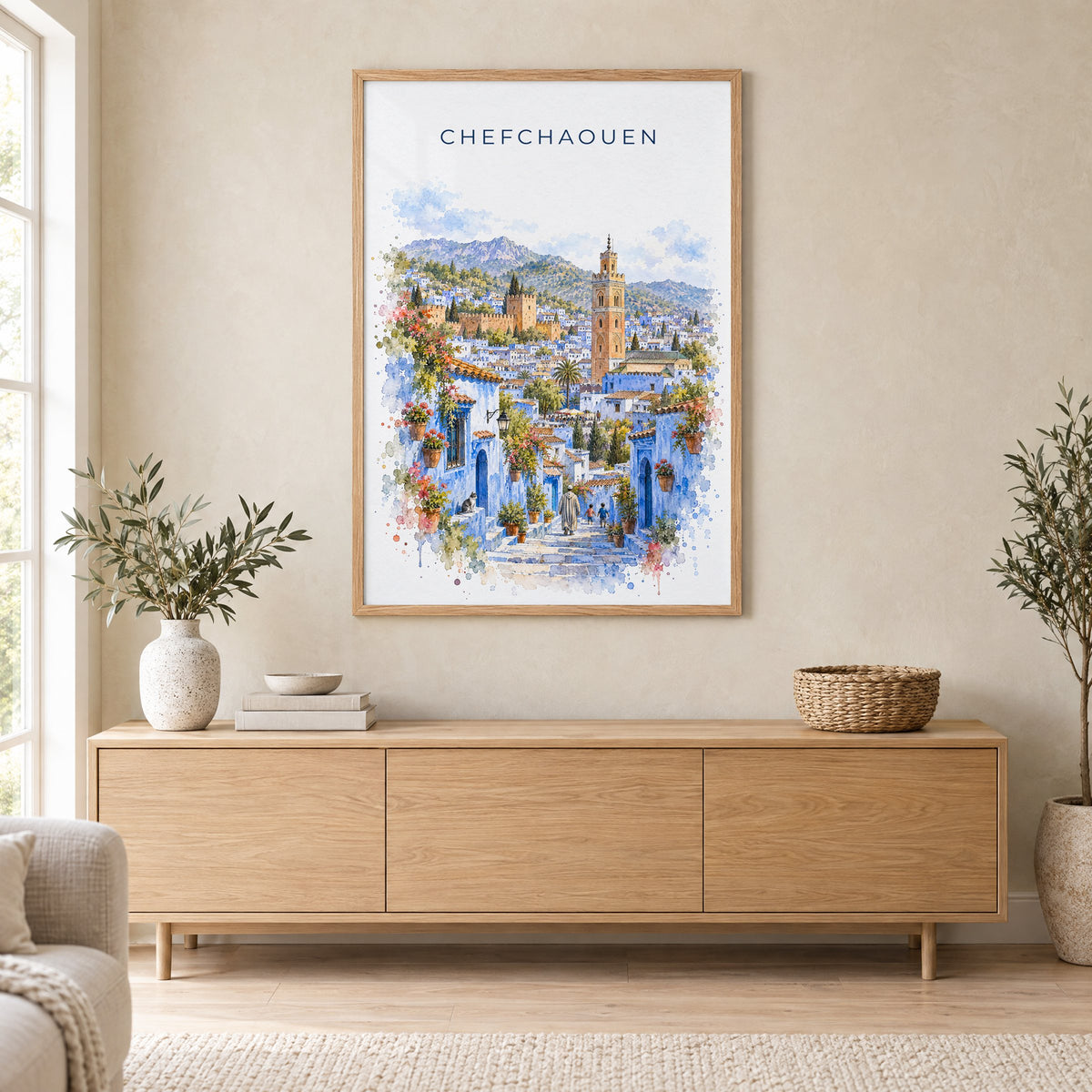 Chefchaouen watercolor print in an oak frame above a light wood sideboard in a Scandinavian living room