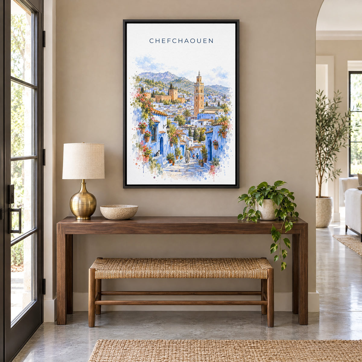 Chefchaouen watercolor print as a black floater canvas above a walnut console and woven bench in an entryway