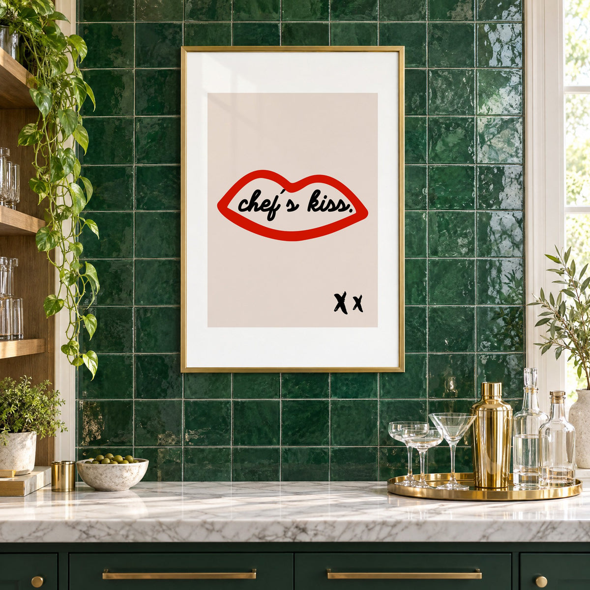 Chef's kiss red lips outline print in a brass frame on emerald green tiles above a home bar with coupe glasses