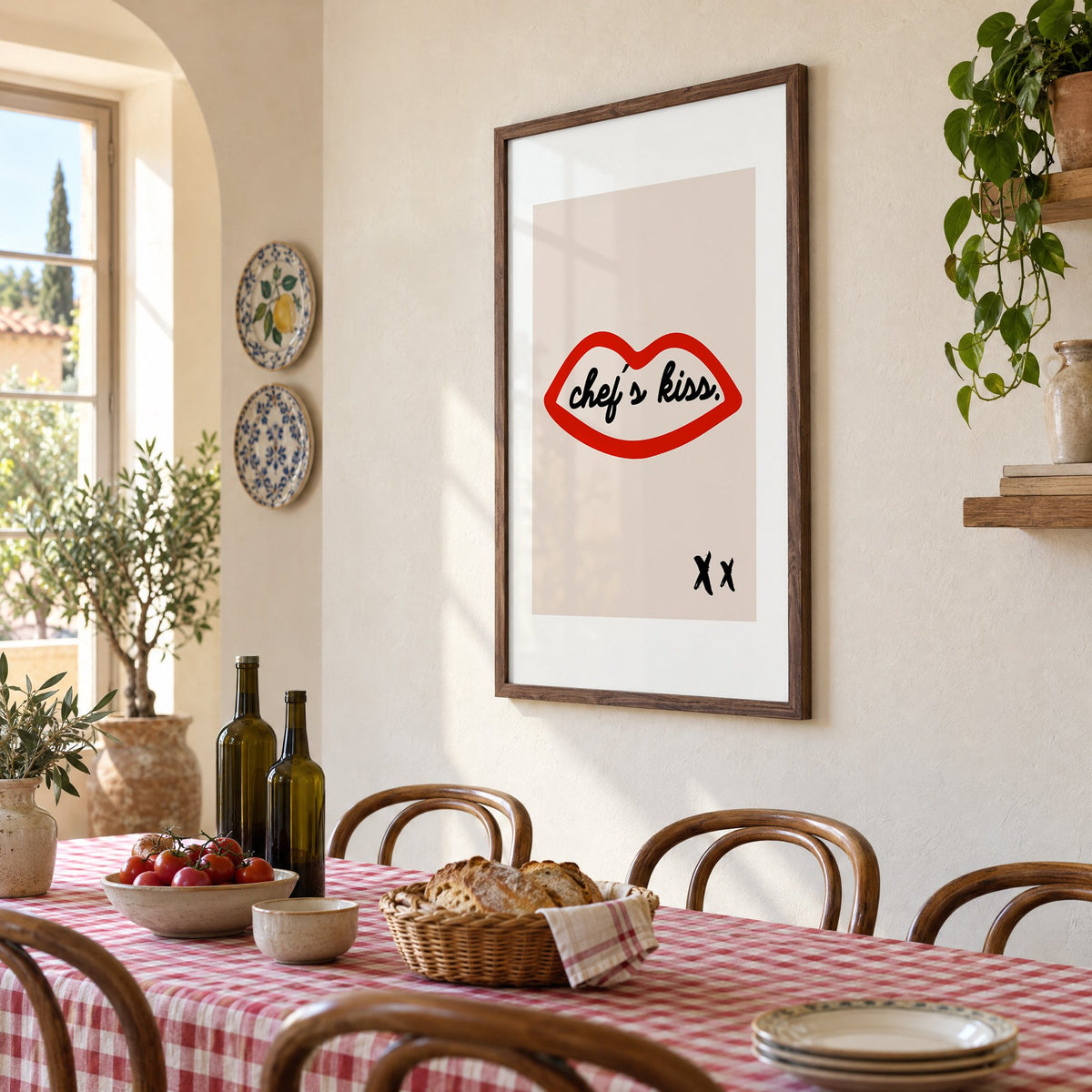 Chef's kiss red lips outline print in a walnut frame above a gingham-covered trattoria table, seen at an angle