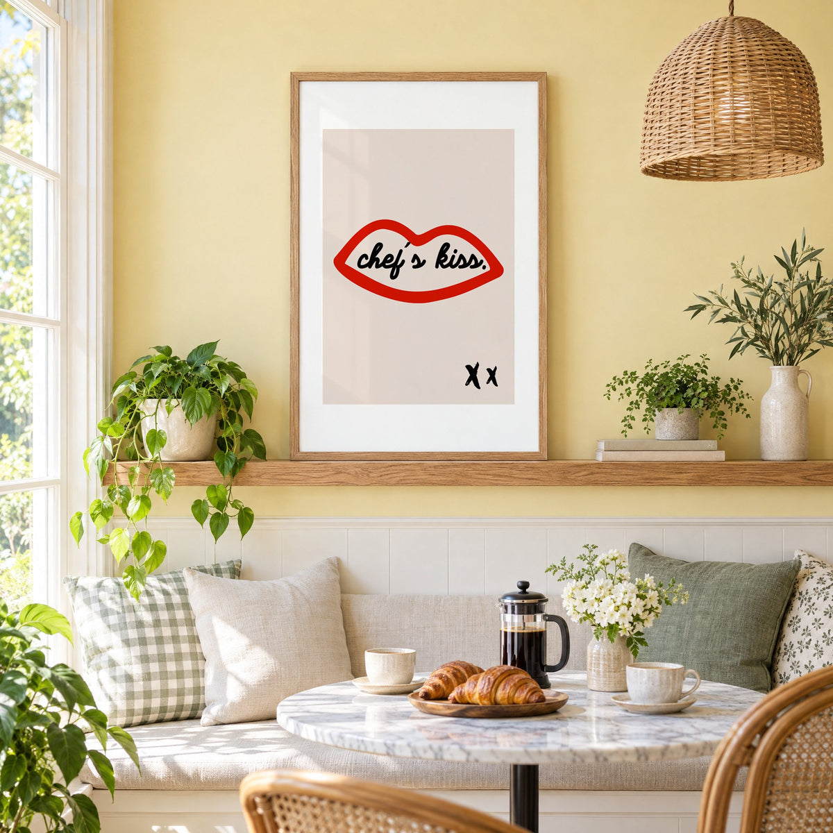 Chef's kiss red lips outline print in an oak frame on a picture ledge above a sunny breakfast nook