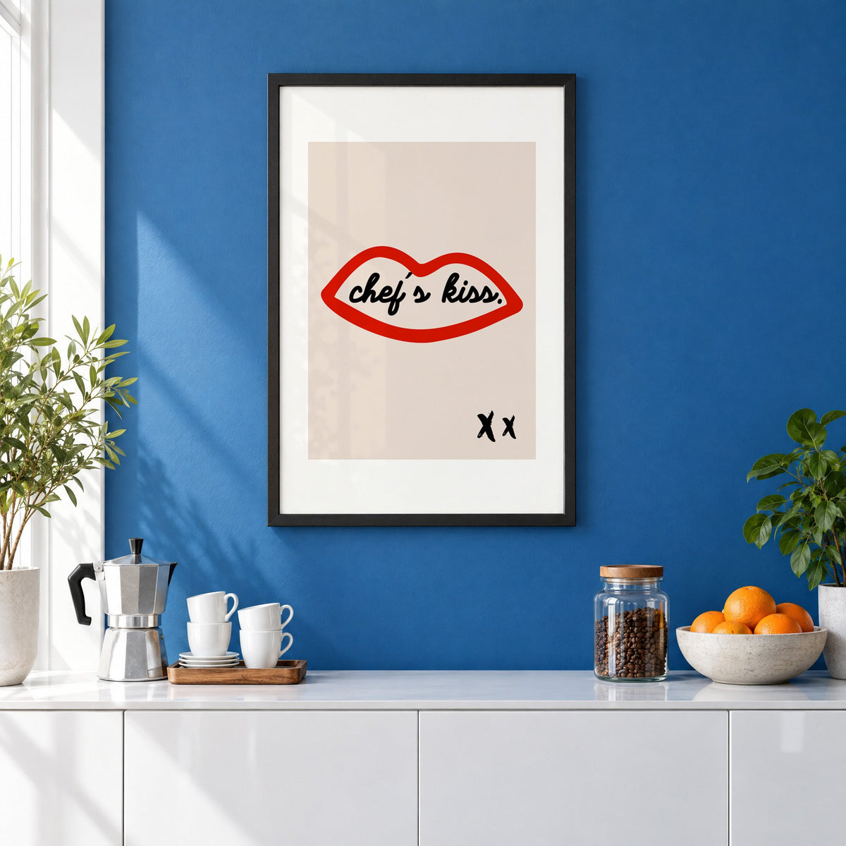 Chef's kiss red lips outline print in a black frame on a cobalt blue wall above a coffee station