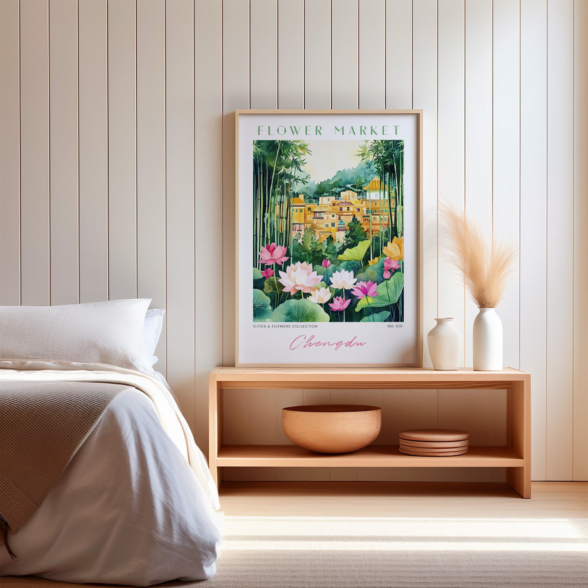 Chengdu flower market print in an oak frame on a wood bench against a white shiplap bedroom wall with pampas grass