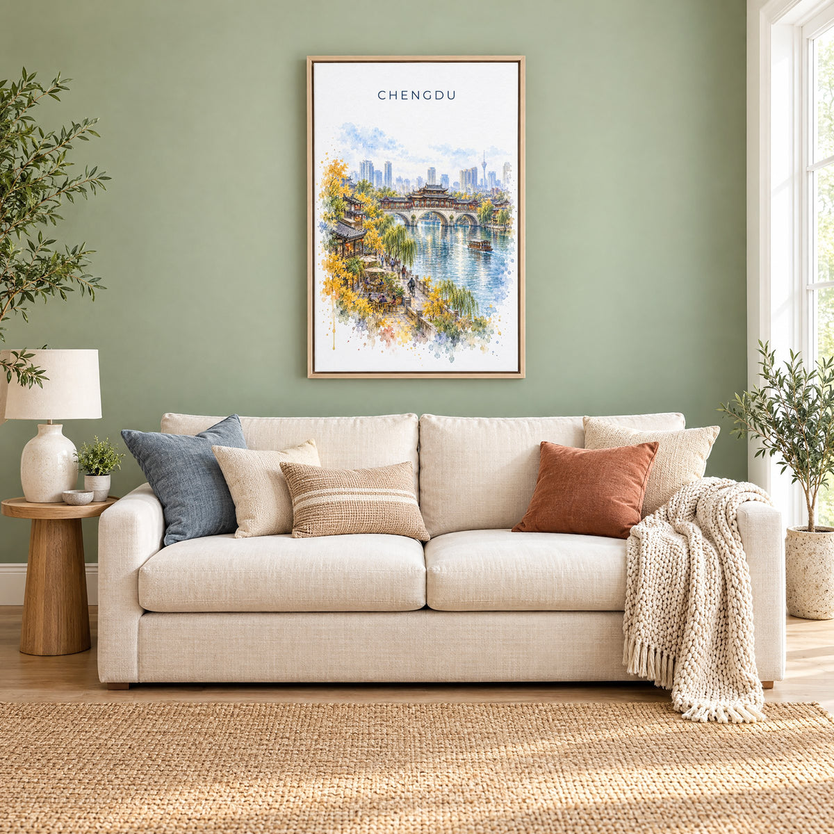 Chengdu watercolor print as a natural floater canvas above a cream linen sofa on a sage green wall