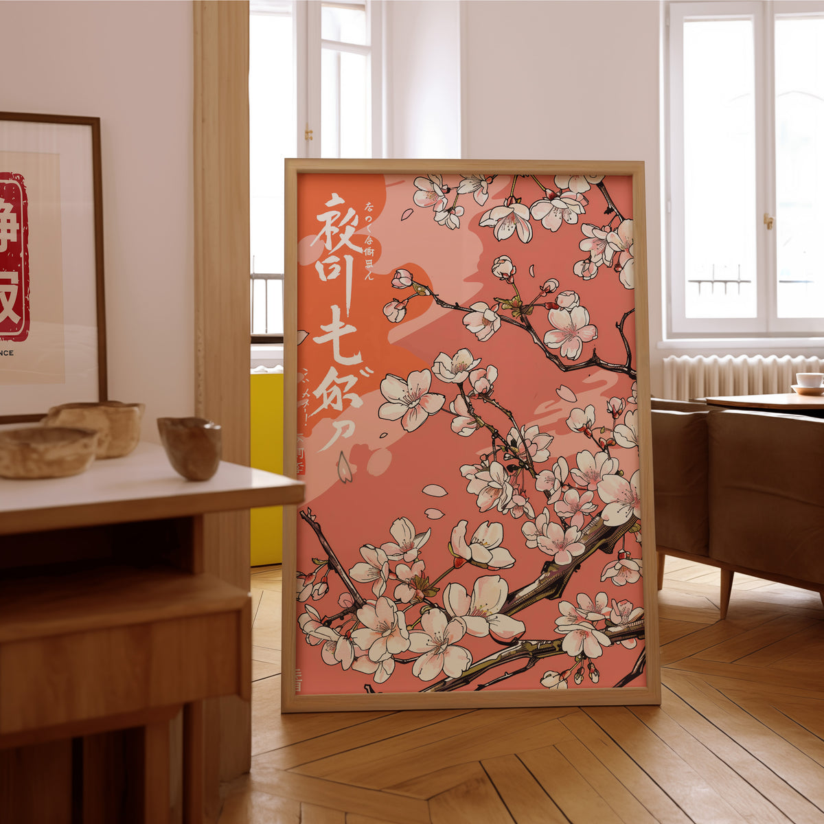 Cherry blossom branch on coral print in an oak frame on the parquet floor of a sunlit living room