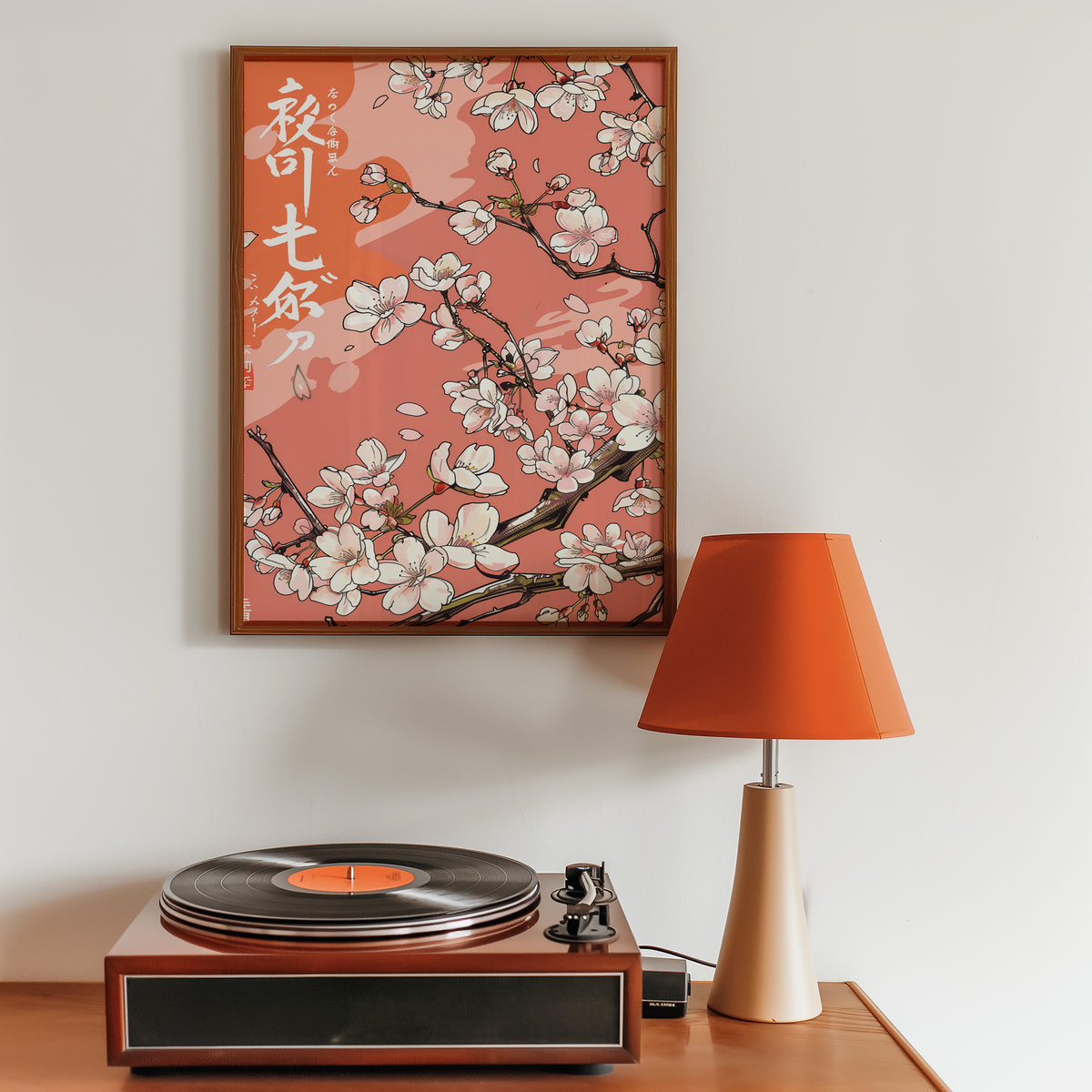 Cherry blossom branch on coral print in a walnut frame above a sideboard with a record player
