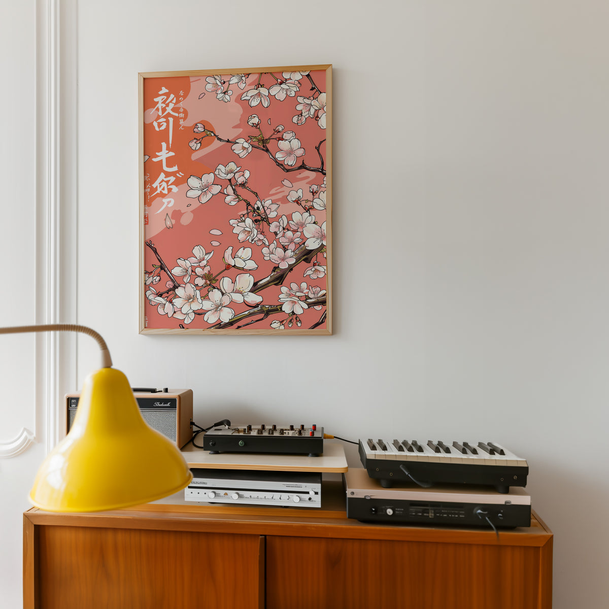Cherry blossom branch on coral print in an oak frame above a teak sideboard with vintage hi-fi