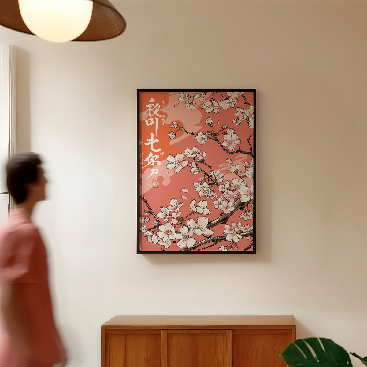 Cherry blossom branch on coral print in a black frame in a hallway under a rattan pendant