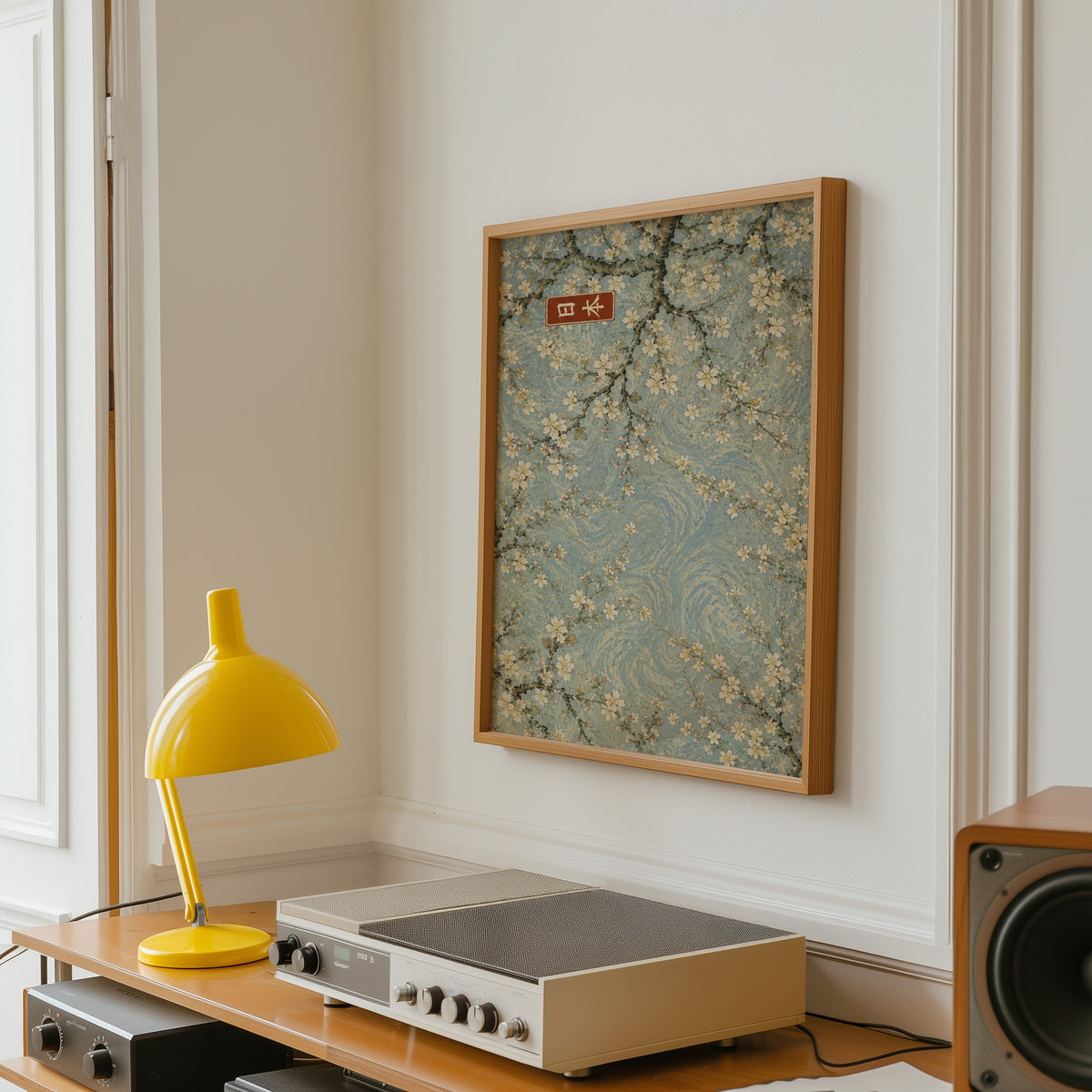 Cherry blossoms blue sky poster in an oak frame above a vintage hi-fi shelf with a yellow desk lamp