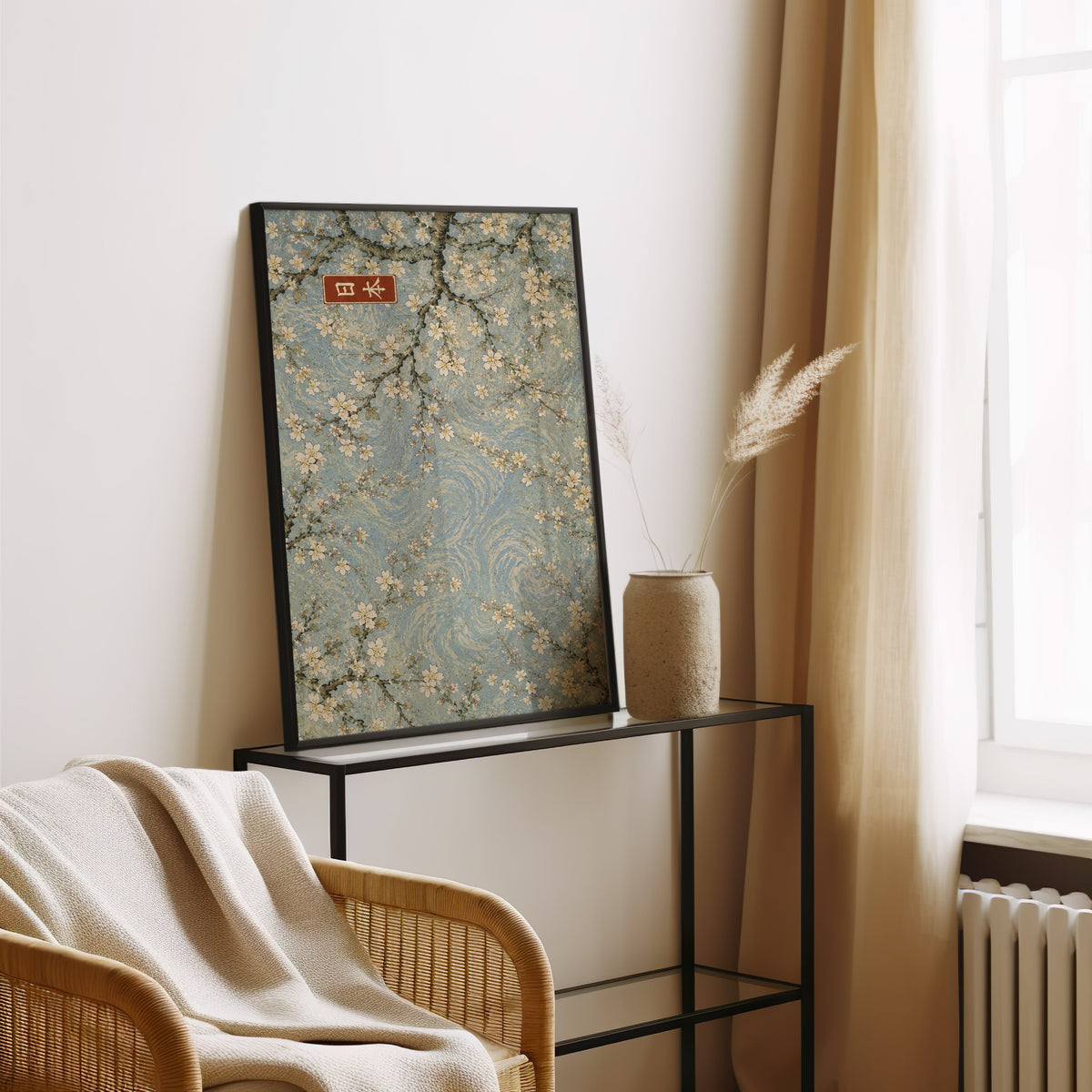 Cherry blossoms blue sky poster in a black frame leaning on a glass console beside pampas grass