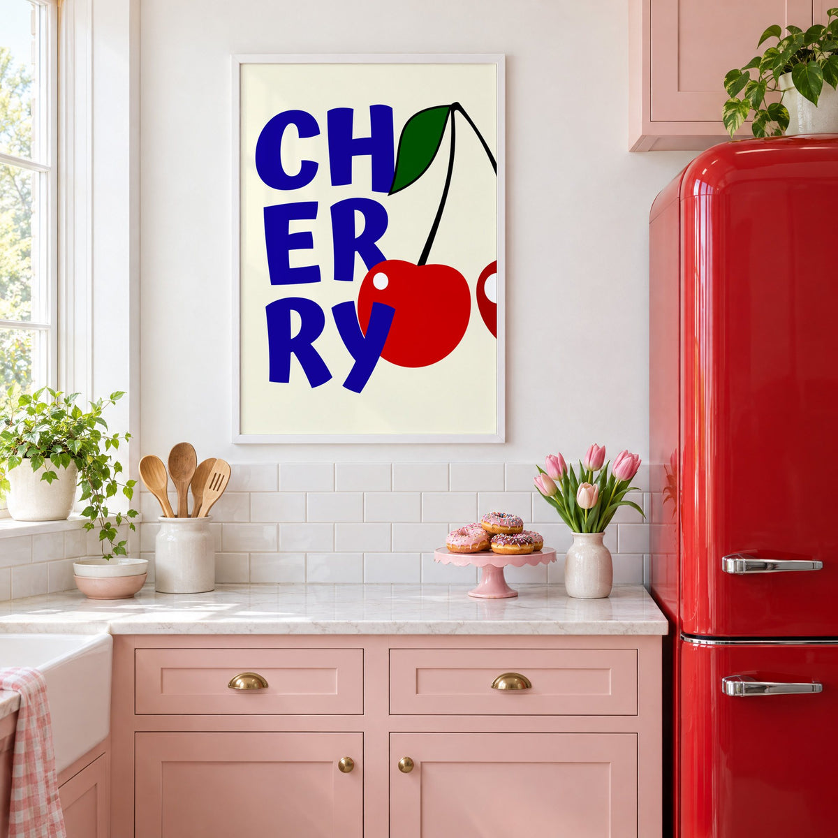 Cherry bold navy letters print in a white frame in a pink kitchen beside a red retro fridge