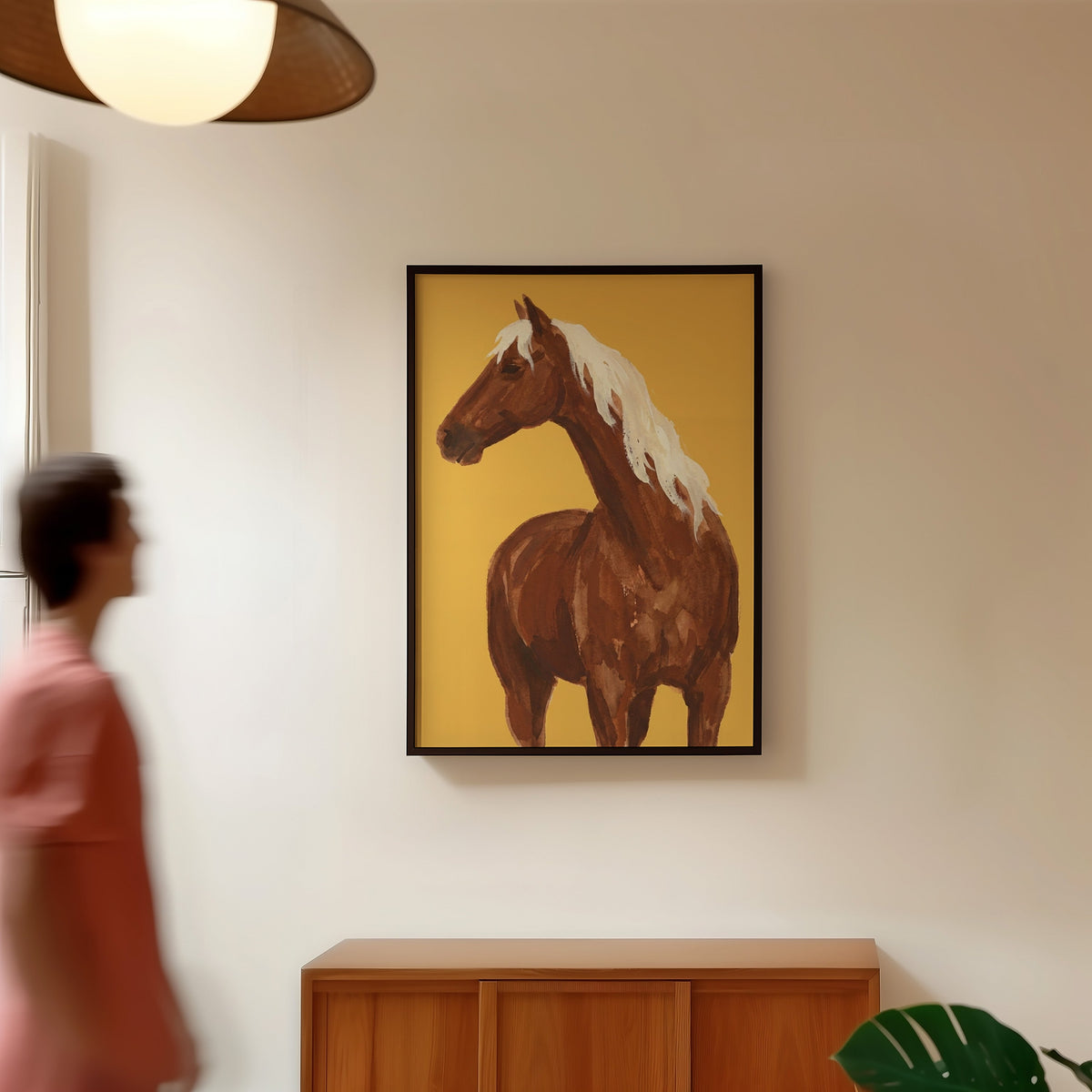 Watercolor horse portrait print in a black frame in a hallway under a rattan pendant