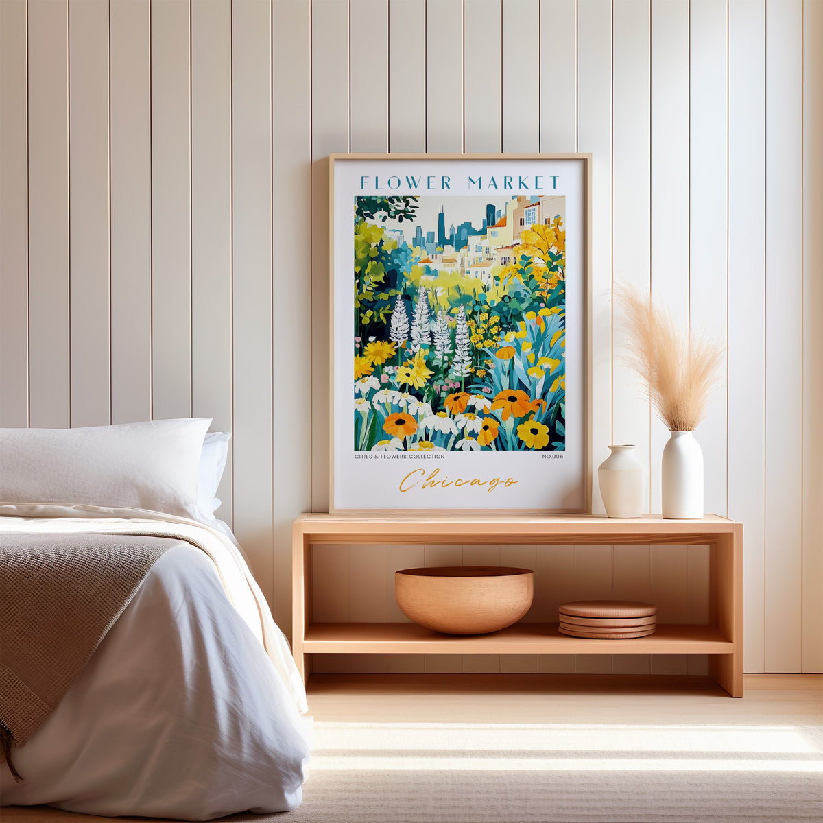 Chicago flower market print in an oak frame on a wood bench against a white shiplap bedroom wall with pampas grass