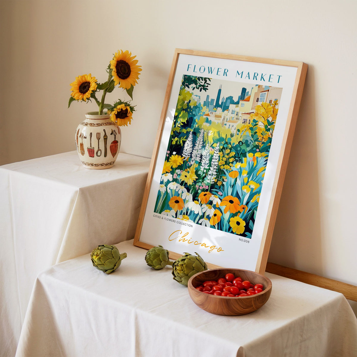 Chicago flower market print in an oak frame leaning on a linen-draped table beside a vase of sunflowers
